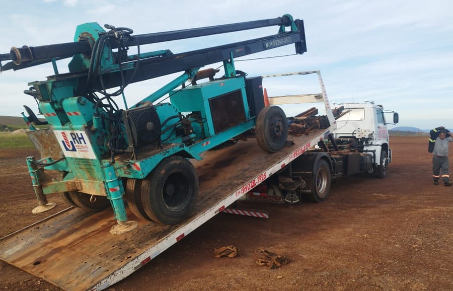 Foto do equipamento: Perfuratriz hidráulica telescópica sobre caminhão plataforma, em movimentação no canteiro de obra.